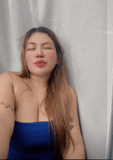 a woman with her eyes closed has a tattoo on her arm that says ' a '