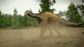 a large dinosaur is walking through a dirt field