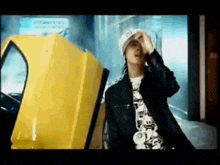 a man is standing in front of a yellow car .