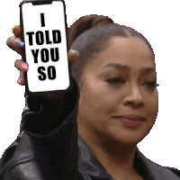 a woman holds up a cell phone that says i told you so