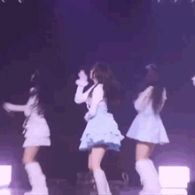 a group of women are dancing on a stage in front of a microphone .