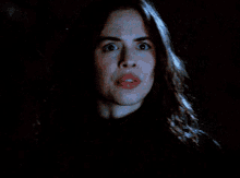 a woman with long hair is making a surprised face
