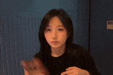 a woman in a black shirt is holding a bottle that says ' coca-cola ' on it
