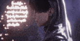 a close up of a person 's face with a neon sign behind them that says ' a ' on it
