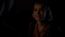a woman in a dark room with a light on her face