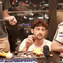 a group of people are sitting at a table eating food and drinking .