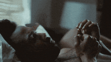 a man is laying on a bed with his eyes closed