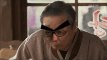 a man wearing glasses has a sticker on his forehead that says sbs hd