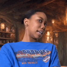a woman wearing a blue harley davidson shirt looks at the camera