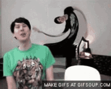 a man in a green shirt with a tiger on it is standing in front of a painting of a monkey .