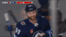 a hockey player stands in front of a scoreboard that says goal on it
