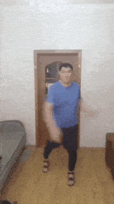 a man in a blue shirt is dancing in front of a door