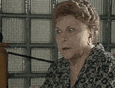 a woman wearing a black shirt with white circles on it looks at the camera