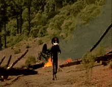 a man in a military uniform is standing in front of a fire