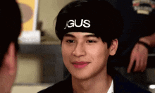 a young man wearing a headband that says j gus is smiling .