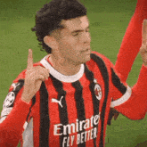 a soccer player wearing an emirates fly better shirt