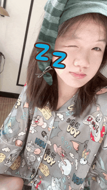 a woman wearing a tom and jerry pajama top is taking a selfie