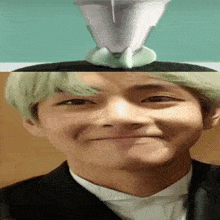 a close up of a man 's face with a cup on top of his head