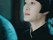 a close up of a woman 's face with short black hair
