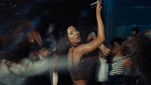 a woman in a brown bra is dancing in a crowd