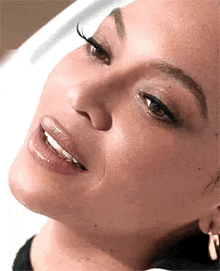 a close up of a woman 's face with her tongue out and a smile on her face .