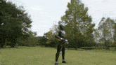 a man in a superhero costume is standing in a field with trees in the background