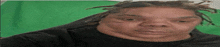a man with dreadlocks on his head is making a funny face .