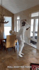 a person in a bunny costume is dancing in a dining room with the words roll away the ton written below them