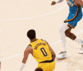 a basketball player with the number 0 on his back dribbles the ball