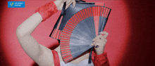 a woman is holding a fan in front of her face and a blue sign that says up front works