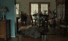a person laying on the floor in a living room with a table and chairs