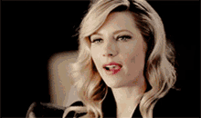 a close up of a woman 's face with blonde hair and red lipstick