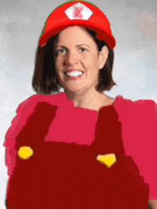 a woman wearing overalls and a red hat with k on it