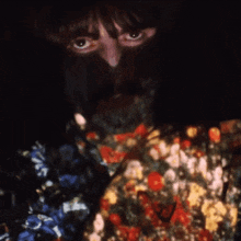 a close up of a person 's face with flowers on their shirt