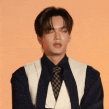 a man with his eyes closed wearing a vest and tie