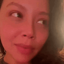 a close up of a woman 's face with a red background and a blurred background .