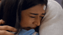 a woman with a bandage on her forehead is laying on a bed .