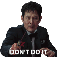 a man in a suit and tie is pointing at the camera with the words " don 't do it "