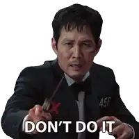 a man in a suit and tie is pointing at the camera with the words " don 't do it "