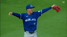 a man wearing a blue jays jersey throws a ball