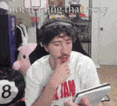 a man wearing a shirt that says ' all jam ' is reading a book