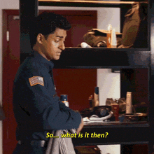 a man in a blue uniform is standing in front of a shelf and asking " so what is it then "