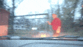 a blurry picture of a man in a red shirt standing on a road