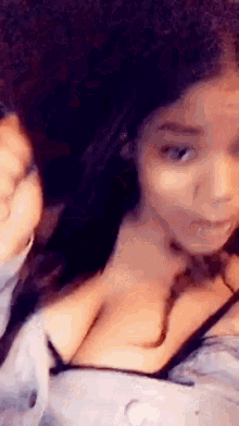 a close up of a woman 's face and breasts in a crop top .