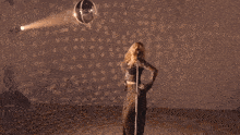 a woman is holding a microphone in her hand and dancing .