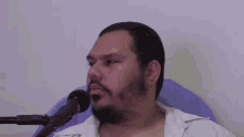 a man with a beard is wearing sunglasses and a white shirt