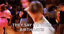 a group of people are dancing in a room and they say it 's your birthday !