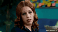 a woman with red hair is making a funny face while wearing headphones .