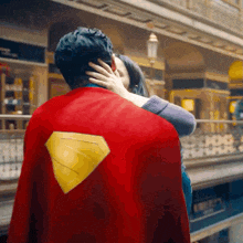 a man in a superman cape kissing a woman
