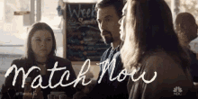 a group of people sitting at a table with the words watch now written on the bottom